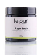 Le Pur Organics sugar scrub jar with textured sugar crystals and natural skincare ingredients, showcasing organic exfoliation.